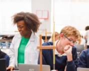 Researchers discussing with students in a classroom setting