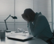 Professional man struggling with emotions at desk