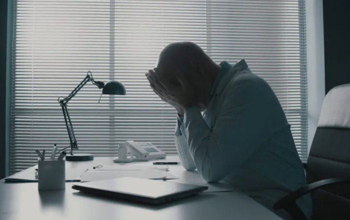 Professional man struggling with emotions at desk