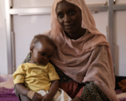 A Sudanese woman holds her child who lacks food and is in need of medical attention